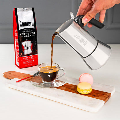 Pouring a cup of fresh italian coffee from Bialetti induction friendly coffee maker Venus stainless steel range