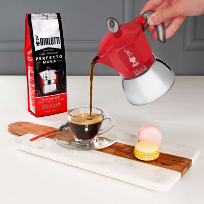 pouring Italian coffee from Bialetti red moka induction